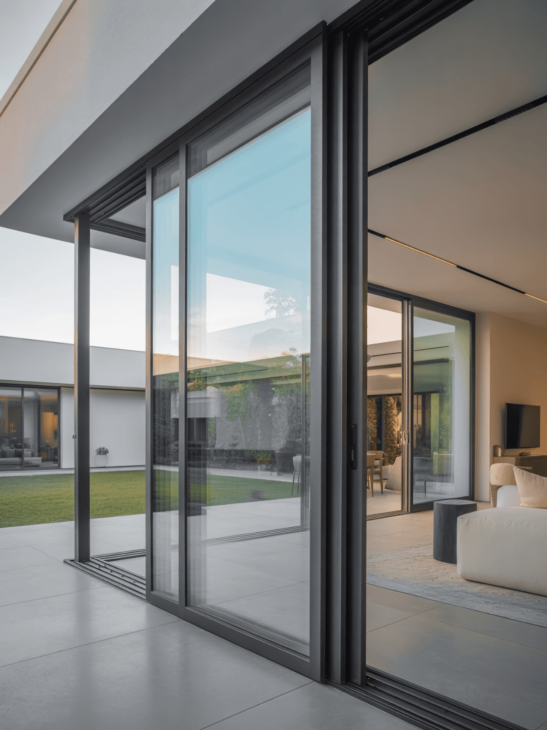 Large floor-to-ceiling sliding glass doors opening to a modern patio and garden.